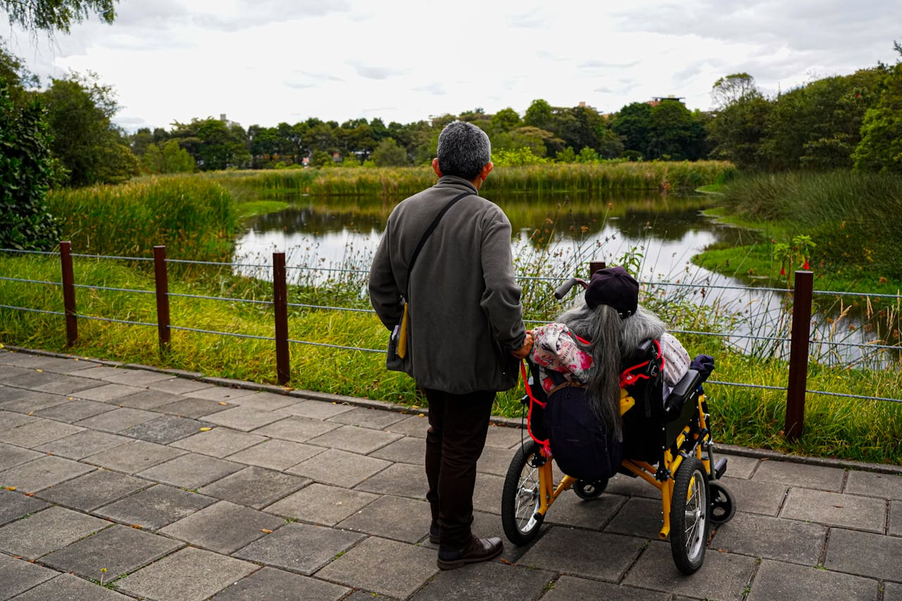 A serene moment of a senior couple by a lake, reflecting on life and natural beauty.